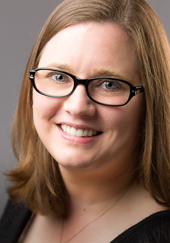 Janna Willoughby wearing rectangular glasses and smiling at the camera